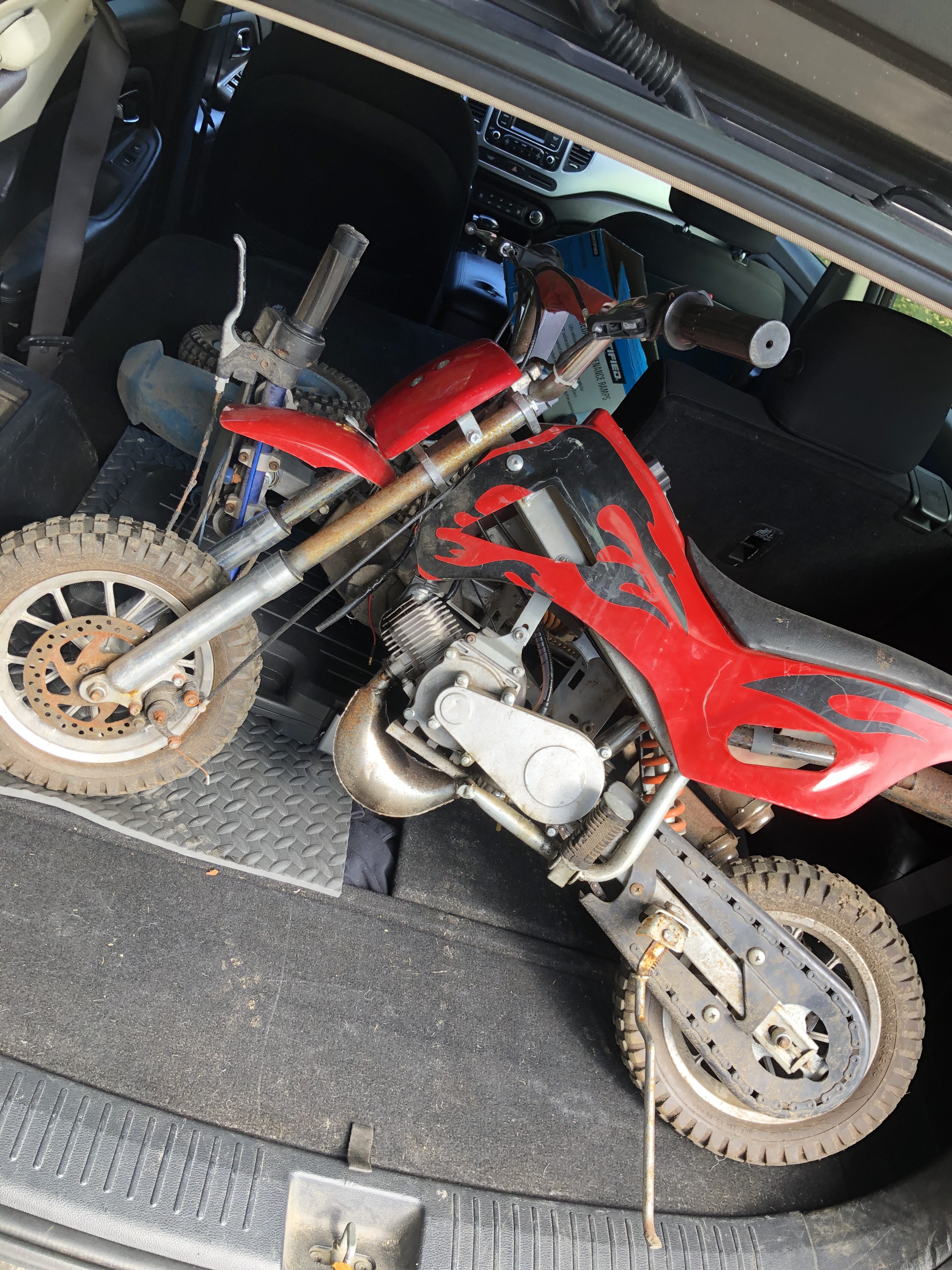 Two small motorbikes in the trunk of a car