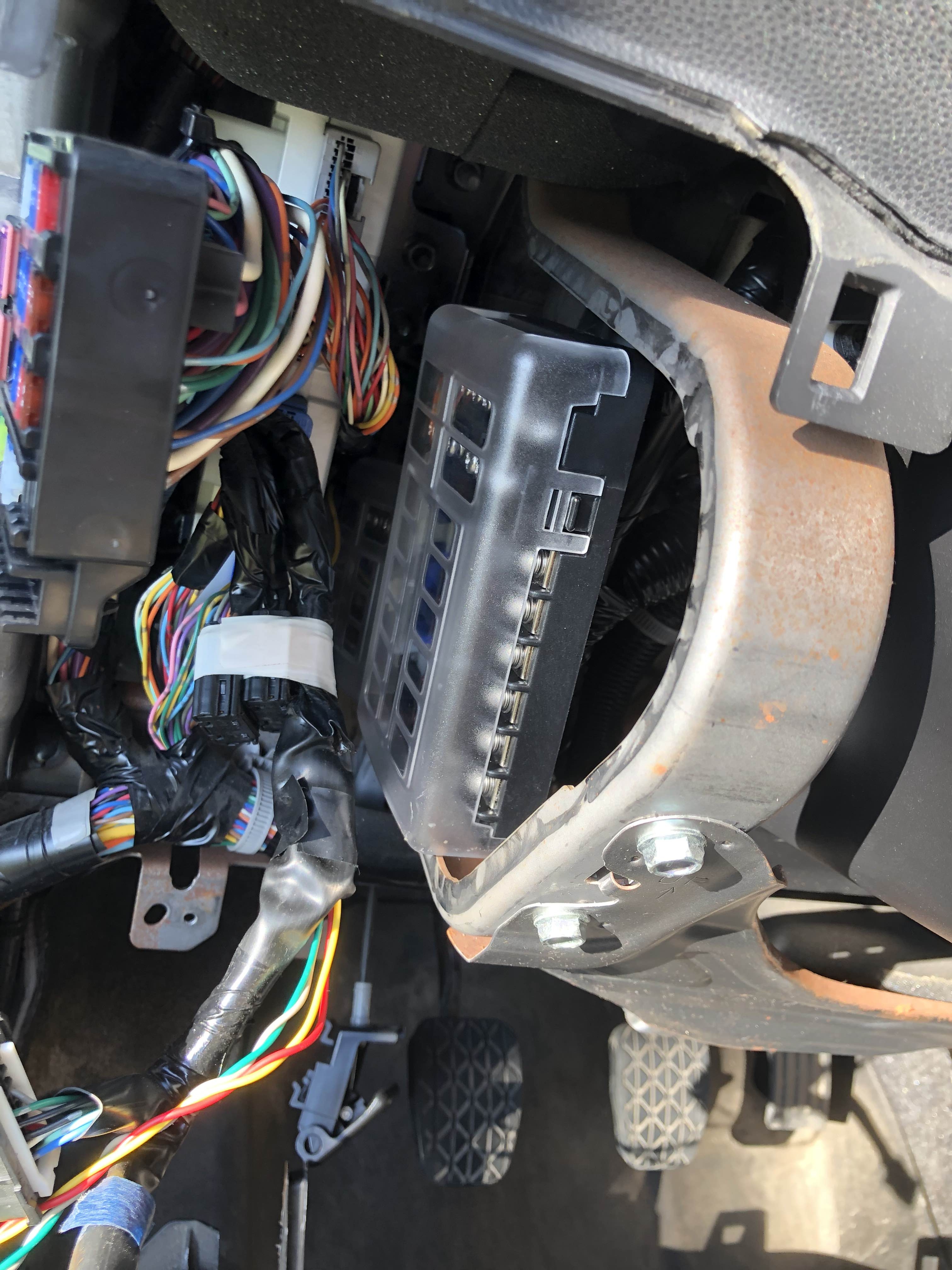 Fuse box loosely placed in car frame